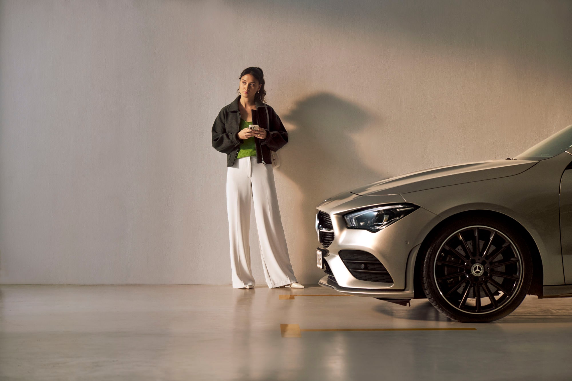Service Select | Mercedes-Benz Een vrouw staat voor een Mercedes-Benz.