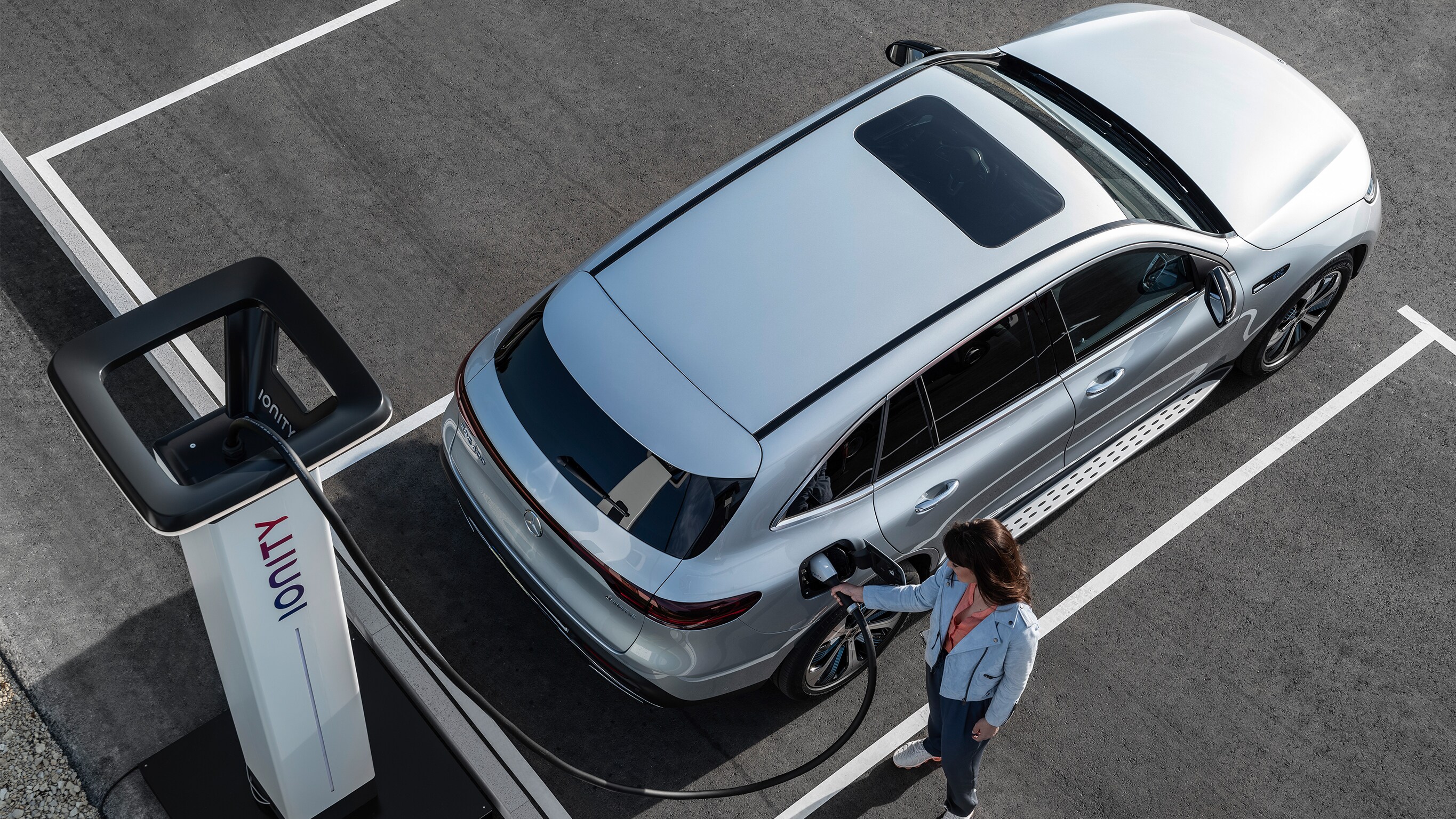 Met Mercedes-Benz en IONITY opladen bij een publiek oplaadpunt Een persoon laadt een Mercedes-Benz op bij een IONITY-oplaadpunt