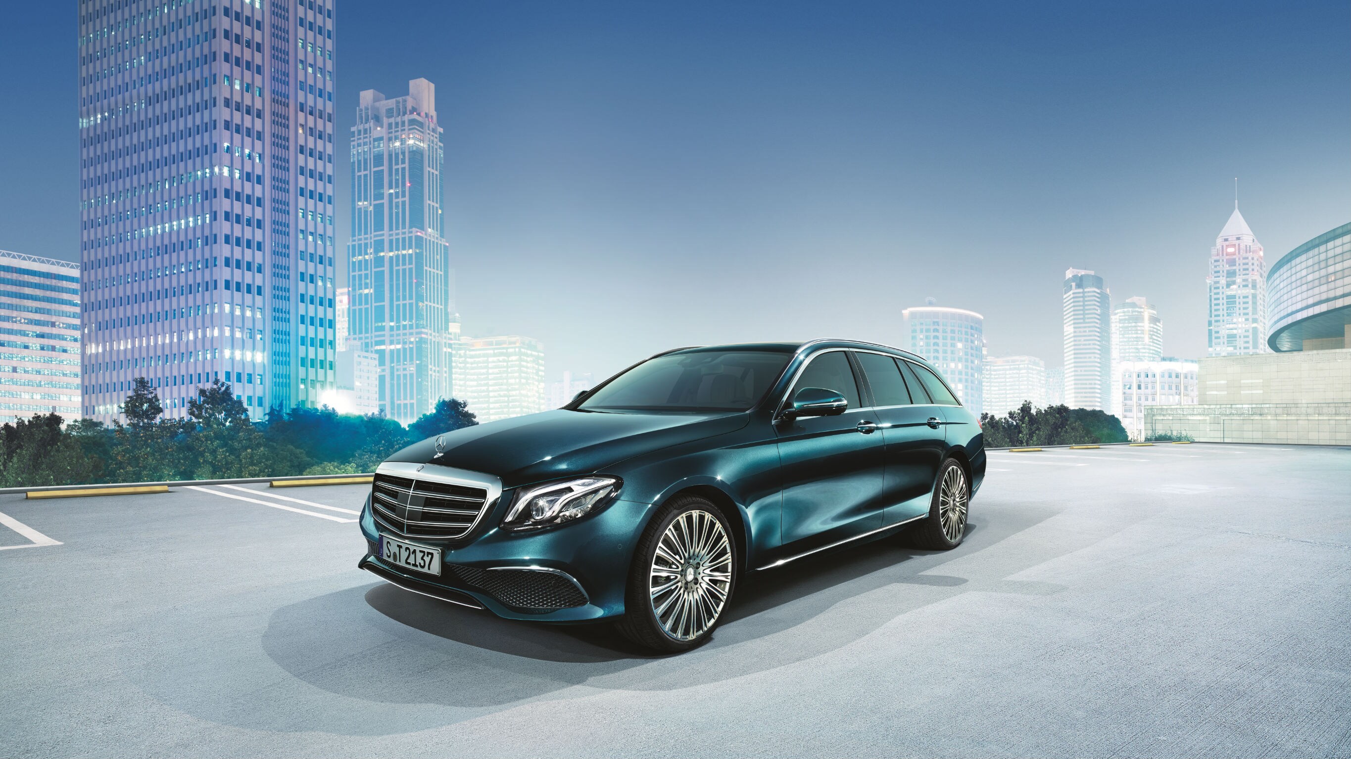 Mercedes-Benz: Expatriate Services Het beeld toont een Mercedes-Benz E-Klasse op een parking met op de achtergrond gebouwen.